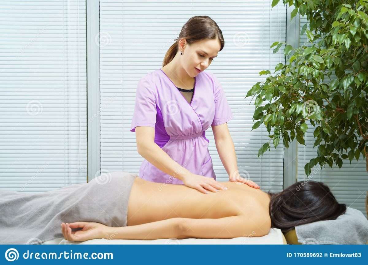 Young Woman Receiving Back Massage From Female Physiotherapist Stock ...